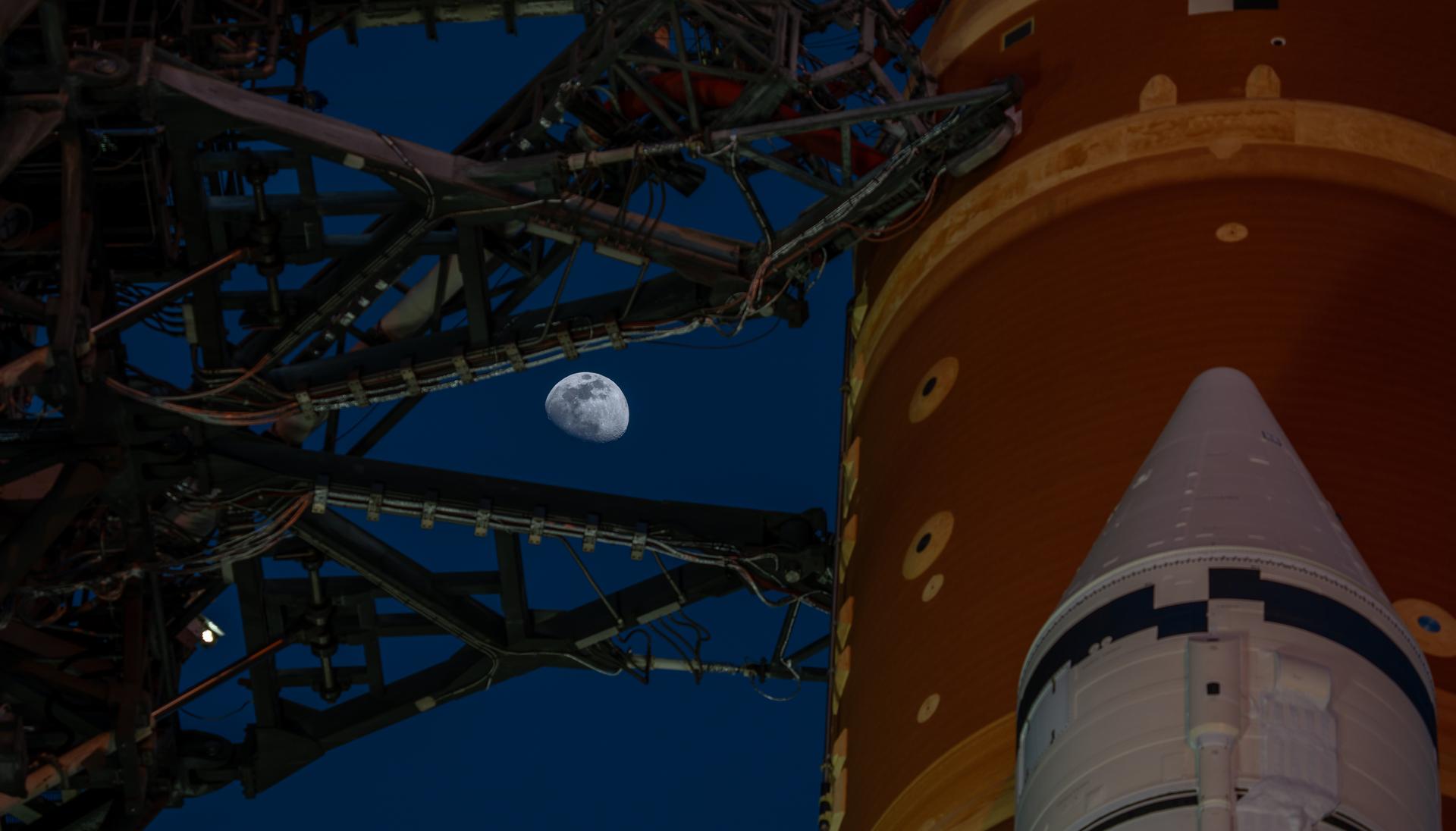 The Moon is seen shining over the SLS (Space Launch System) and Orion spacecraft, atop the mobile launcher on January 28, 2026. The rocket is currently at Launch Pad 39B at NASA’s Kennedy Space Center in Florida, as teams are preparing for a wet dress rehearsal to practice timelines and procedures for the launch of Artemis II.